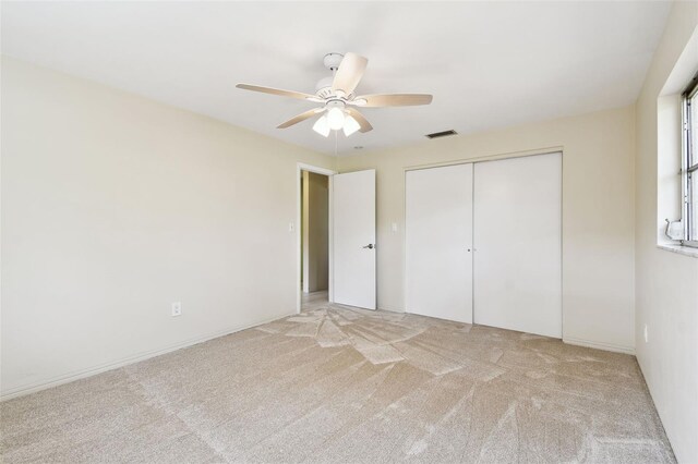 5825 Oakhurst Dr, Seminole, FL 33772 - unfurnished bedroom featuring light carpet, a closet, and ceiling fan