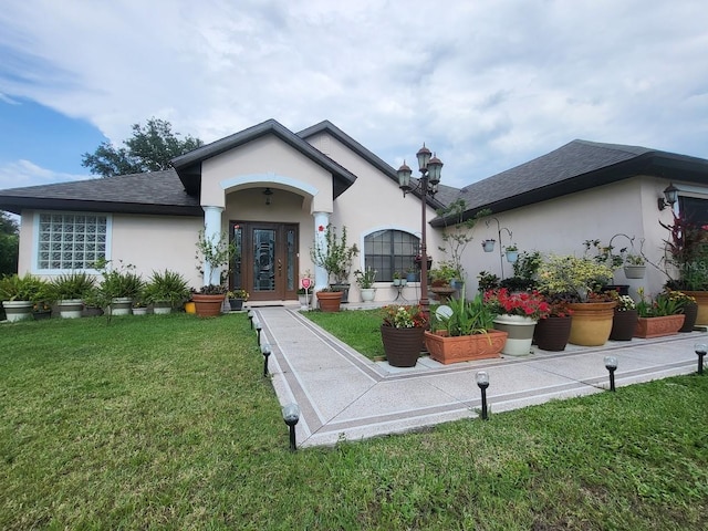 4471 Marsh Harbor Dr, Tavares, FL 32778 - view of front facade featuring stucco siding, a front yard, and roof with shingles