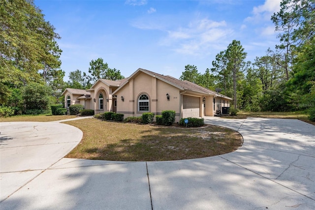 8518 N Linwood Loop, Citrus Springs, FL 34433 - view of front of property with stucco siding, driveway, a garage, and a front lawn