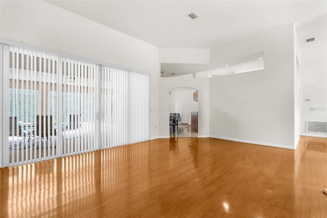 8518 N Linwood Loop, Citrus Springs, FL 34433 - spare room featuring arched walkways, wood finished floors, and baseboards