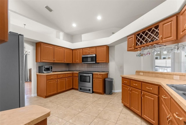 8518 N Linwood Loop, Citrus Springs, FL 34433 - kitchen featuring stainless steel appliances, backsplash, brown cabinetry, and recessed lighting