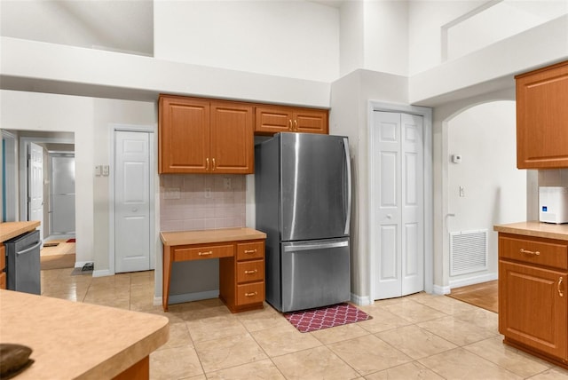 8518 N Linwood Loop, Citrus Springs, FL 34433 - kitchen featuring appliances with stainless steel finishes, a towering ceiling, arched walkways, light countertops, and baseboards