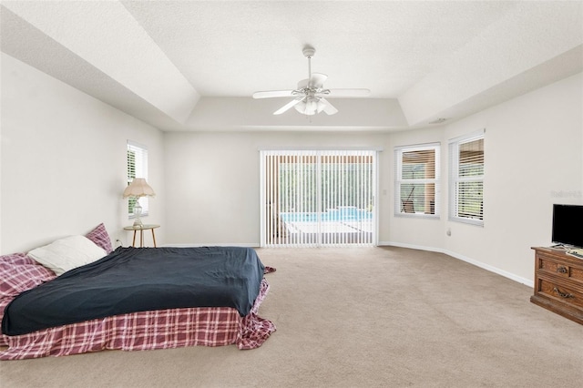 8518 N Linwood Loop, Citrus Springs, FL 34433 - carpeted bedroom with a tray ceiling, access to exterior, a ceiling fan, and baseboards