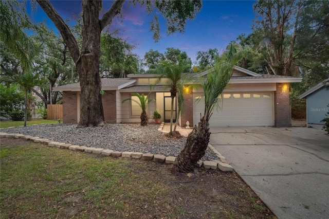 1613 Long Pond Dr, Valrico, FL 33594 - mid-century modern home with brick siding, a garage, and driveway