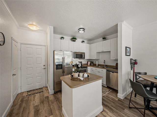 4221 W Spruce St Unit 2302, Tampa, FL 33607 - kitchen featuring stainless steel appliances, a sink, dark wood-style flooring, crown molding, and white cabinets