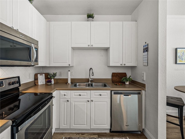 4221 W Spruce St Unit 2302, Tampa, FL 33607 - kitchen featuring appliances with stainless steel finishes, a sink, white cabinetry, and a textured wall