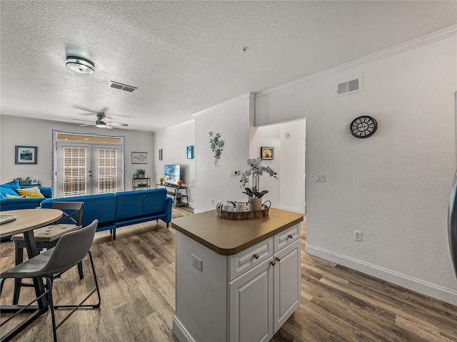 4221 W Spruce St Unit 2302, Tampa, FL 33607 - kitchen with dark wood-style flooring, dark countertops, a textured ceiling, a kitchen island, and a ceiling fan