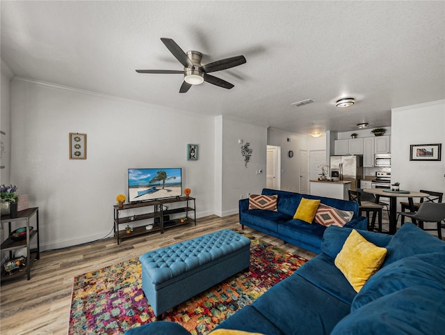 4221 W Spruce St Unit 2302, Tampa, FL 33607 - living room with light wood-style flooring, a ceiling fan, baseboards, ornamental molding, and a textured ceiling