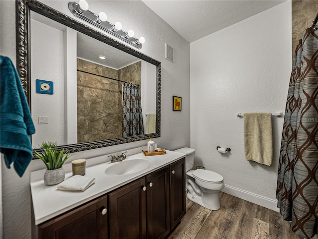 4221 W Spruce St Unit 2302, Tampa, FL 33607 - bathroom with a textured wall, wood finished floors, vanity, toilet, and a shower with shower curtain