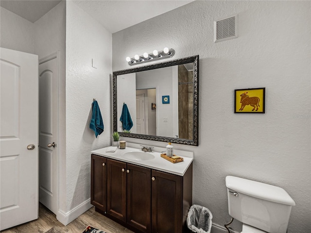 4221 W Spruce St Unit 2302, Tampa, FL 33607 - bathroom with vanity, wood finished floors, a textured wall, toilet, and baseboards