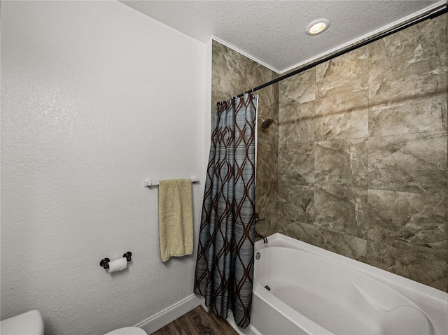 4221 W Spruce St Unit 2302, Tampa, FL 33607 - bathroom featuring toilet, a textured ceiling, shower / bath combination with curtain, wood finished floors, and baseboards
