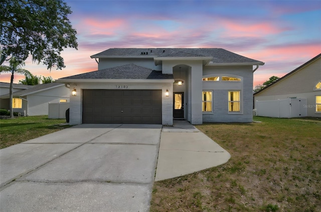 12102 Steppingstone Blvd, Tampa, FL 33635 - view of front of house featuring a garage, driveway, roof with shingles, and brick siding