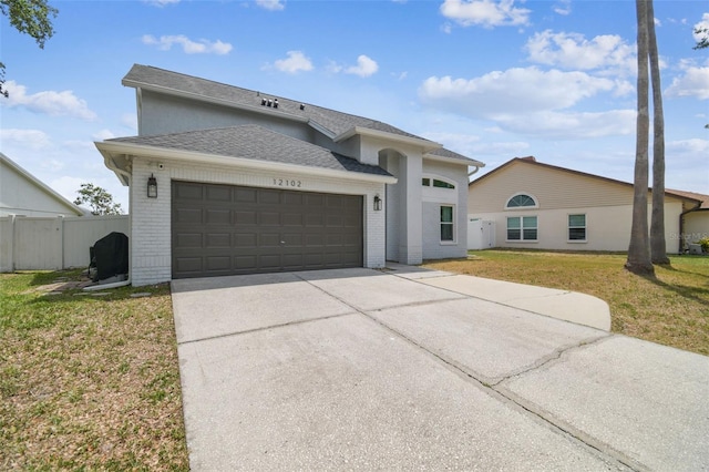12102 Steppingstone Blvd, Tampa, FL 33635 - view of front of home with a garage, driveway, roof with shingles, and brick siding