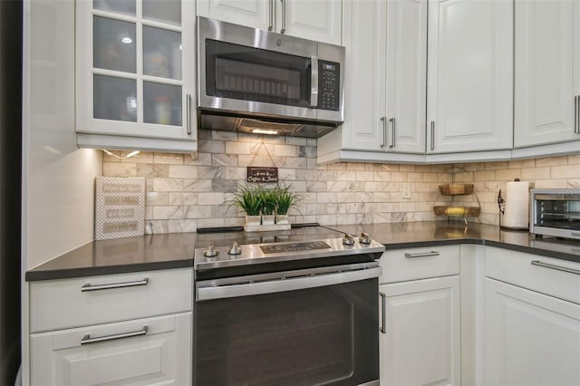 12102 Steppingstone Blvd, Tampa, FL 33635 - kitchen featuring stainless steel appliances, dark countertops, and white cabinets