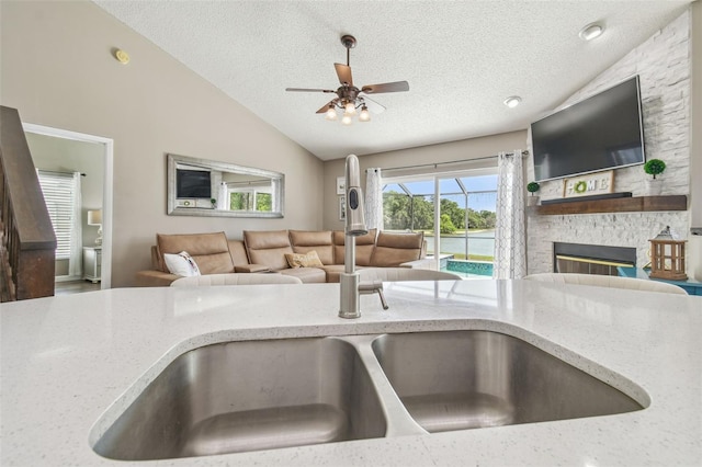 12102 Steppingstone Blvd, Tampa, FL 33635 - kitchen featuring vaulted ceiling, light stone counters, a textured ceiling, a sink, and ceiling fan