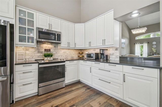 12102 Steppingstone Blvd, Tampa, FL 33635 - kitchen with stainless steel appliances, dark countertops, tasteful backsplash, and glass insert cabinets