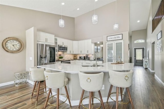 12102 Steppingstone Blvd, Tampa, FL 33635 - kitchen featuring appliances with stainless steel finishes, a sink, high vaulted ceiling, baseboards, and dark wood-style flooring