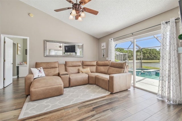 12102 Steppingstone Blvd, Tampa, FL 33635 - living room featuring vaulted ceiling, a textured ceiling, a ceiling fan, and wood finished floors