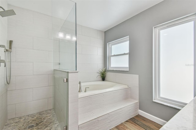 12102 Steppingstone Blvd, Tampa, FL 33635 - bathroom featuring a stall shower, a bath, wood finished floors, and baseboards