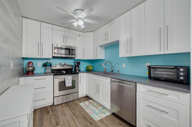 3114 Lake Pine Way Unit G1, Tarpon Springs, FL 34688 - kitchen with stainless steel appliances, a sink, ceiling fan, white cabinets, and light wood-type flooring