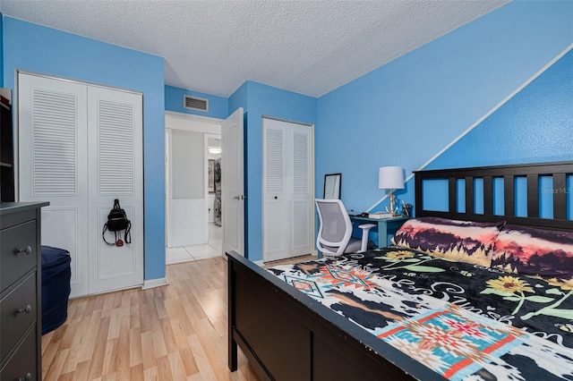 3114 Lake Pine Way Unit G1, Tarpon Springs, FL 34688 - bedroom featuring light wood-style flooring, two closets, and a textured ceiling