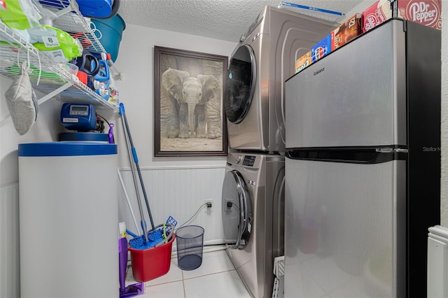 3114 Lake Pine Way Unit G1, Tarpon Springs, FL 34688 - laundry area with stacked washer / dryer, tile patterned floors, wainscoting, and a textured ceiling
