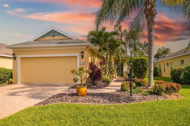 11813 Crawford Parrish Ln, Parrish, FL 34219 - view of front of house with decorative driveway, stucco siding, an attached garage, and a lawn