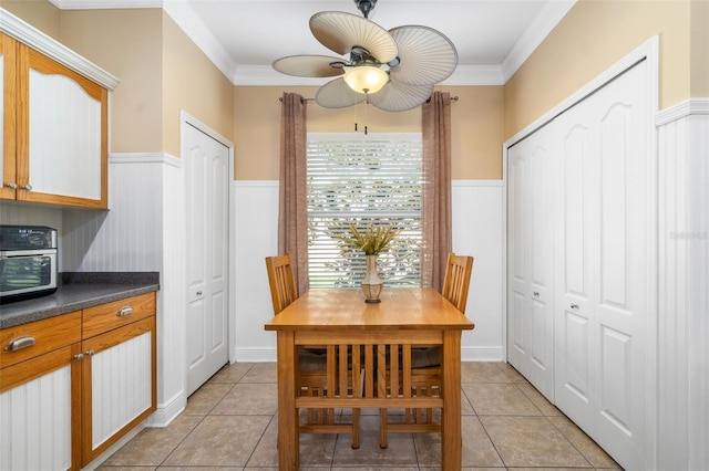 11813 Crawford Parrish Ln, Parrish, FL 34219 - dining room featuring a ceiling fan, wainscoting, ornamental molding, and light tile patterned floors