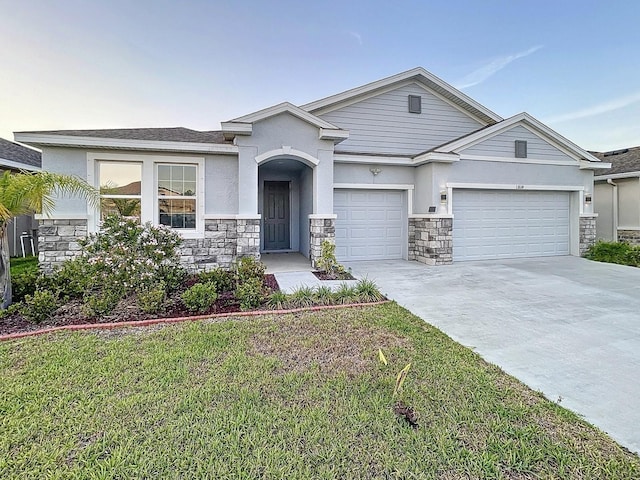 13014 Willow Grove Dr, Riverview, FL 33579 - view of front of home featuring stone siding, a garage, concrete driveway, and stucco siding