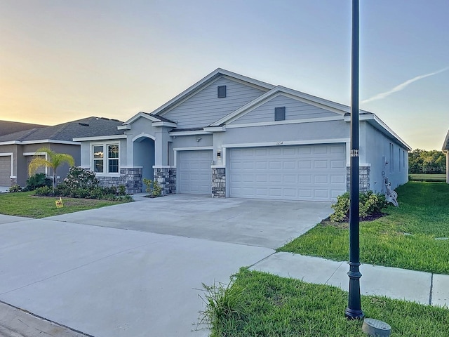 13014 Willow Grove Dr, Riverview, FL 33579 - view of front of house featuring driveway, a lawn, a garage, and stone siding