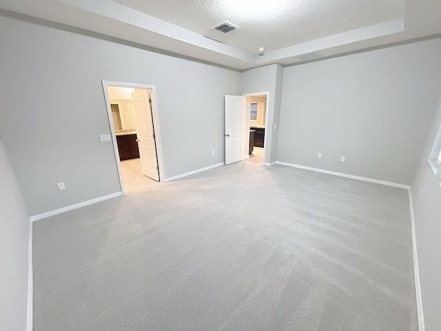 13014 Willow Grove Dr, Riverview, FL 33579 - unfurnished bedroom featuring a tray ceiling, baseboards, a spacious closet, light carpet, and a textured ceiling