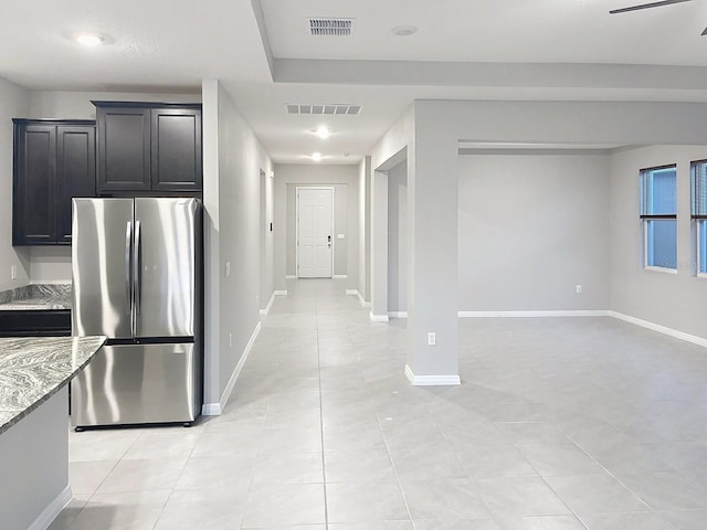 13014 Willow Grove Dr, Riverview, FL 33579 - kitchen with freestanding refrigerator, light stone countertops, light tile patterned floors, baseboards, and dark cabinets