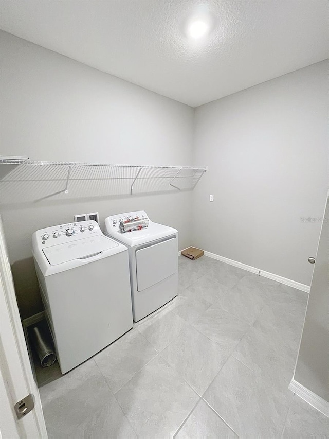 13014 Willow Grove Dr, Riverview, FL 33579 - laundry room featuring washing machine and dryer, baseboards, and a textured ceiling