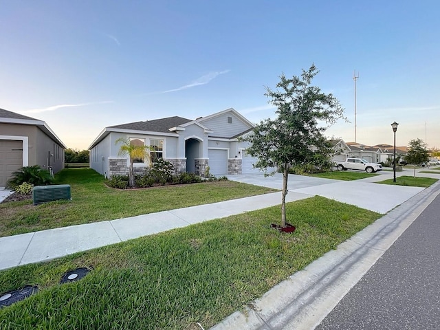 13014 Willow Grove Dr, Riverview, FL 33579 - view of front of home with driveway, a front lawn, stone siding, stucco siding, and a garage