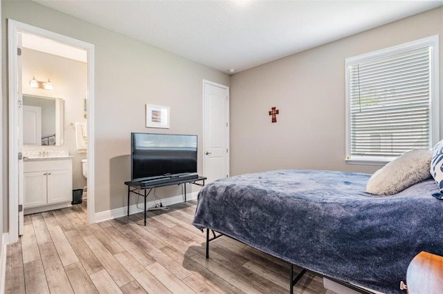 5 Sweetgum Ct N, Homosassa, FL 34446 - bedroom with light wood-type flooring, baseboards, a sink, and ensuite bathroom