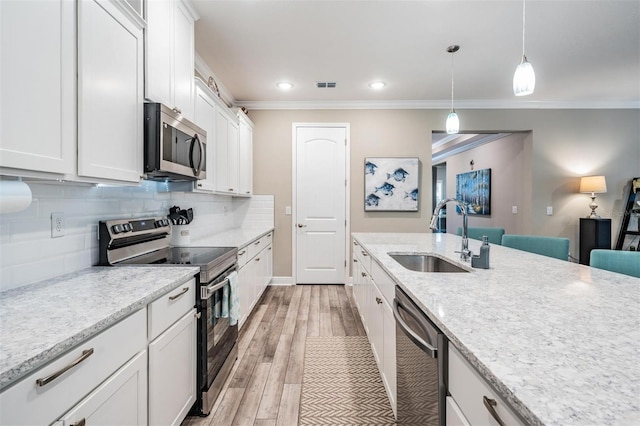 5 Sweetgum Ct N, Homosassa, FL 34446 - kitchen featuring stainless steel appliances, a sink, ornamental molding, white cabinets, and backsplash