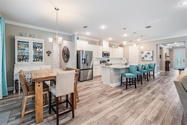5 Sweetgum Ct N, Homosassa, FL 34446 - dining space with light wood-type flooring, crown molding, recessed lighting, baseboards, and a chandelier