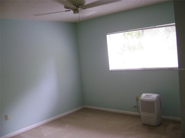 3077 Casa Del Sol Cir Unit 207, Clearwater, FL 33761 - unfurnished room featuring ceiling fan, light carpet, baseboards, and a textured ceiling