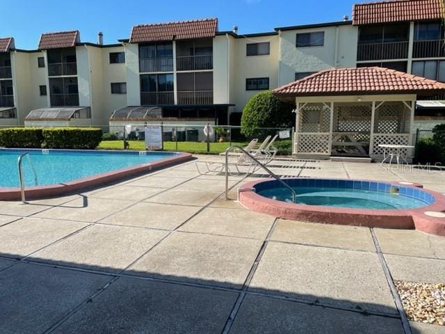 3077 Casa Del Sol Cir Unit 207, Clearwater, FL 33761 - community pool featuring a community hot tub, a gazebo, and a patio