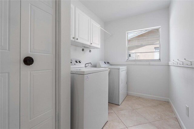 4706 Fox Hunt Dr, Tampa, FL 33624 - laundry room featuring cabinet space, separate washer and dryer, light tile patterned flooring, and baseboards