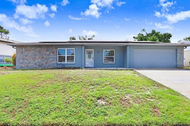 3917 Casaba Loop, Valrico, FL 33596 - view of front of house with an attached garage, stone siding, solar panels, and a front yard