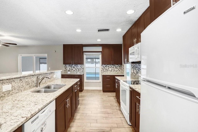 3917 Casaba Loop, Valrico, FL 33596 - kitchen with white appliances, a sink, tasteful backsplash, light wood-style flooring, and a ceiling fan