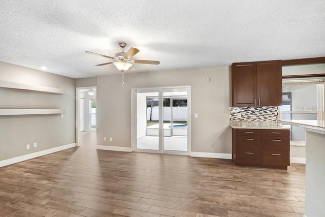 3917 Casaba Loop, Valrico, FL 33596 - unfurnished living room with wood finished floors, a textured ceiling, ceiling fan, and baseboards