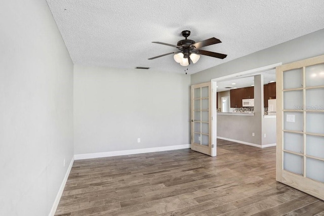 3917 Casaba Loop, Valrico, FL 33596 - unfurnished room with french doors, ceiling fan, a textured ceiling, wood finished floors, and baseboards