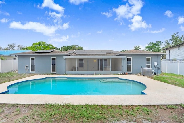 3917 Casaba Loop, Valrico, FL 33596 - back of property featuring a sunroom, roof mounted solar panels, a fenced backyard, stucco siding, and central air condition unit