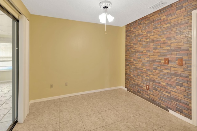 1604 Comfy Ct, Sun City Center, FL 33573 - empty room featuring baseboards, light tile patterned flooring, and brick wall