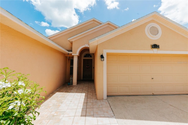 9852 Laurel Ledge Dr, Riverview, FL 33569 - view of exterior entry featuring stucco siding, a garage, and driveway