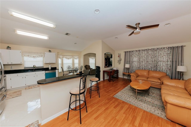 9852 Laurel Ledge Dr, Riverview, FL 33569 - kitchen featuring a breakfast bar, open floor plan, vaulted ceiling, dark countertops, and arched walkways