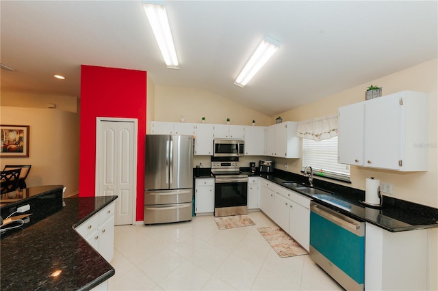 9852 Laurel Ledge Dr, Riverview, FL 33569 - kitchen featuring appliances with stainless steel finishes, lofted ceiling, white cabinets, light tile patterned flooring, and dark stone counters