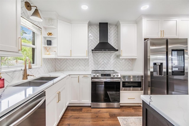 3120 S Polk Ave, Lakeland, FL 33803 - kitchen with stainless steel appliances, wall chimney exhaust hood, a sink, white cabinetry, and tasteful backsplash